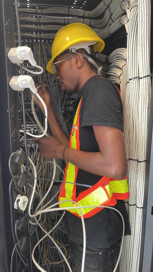 Technology team member working at a network equipment rack